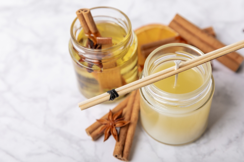 The process of making homemade candles on the table. Close-up. Pouring molten wax. Soy candles handmade with wooden wicks.