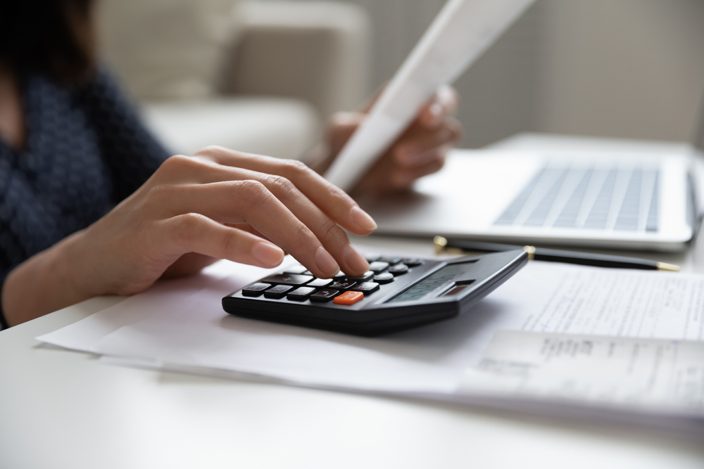 Woman using calculator for budgeting.